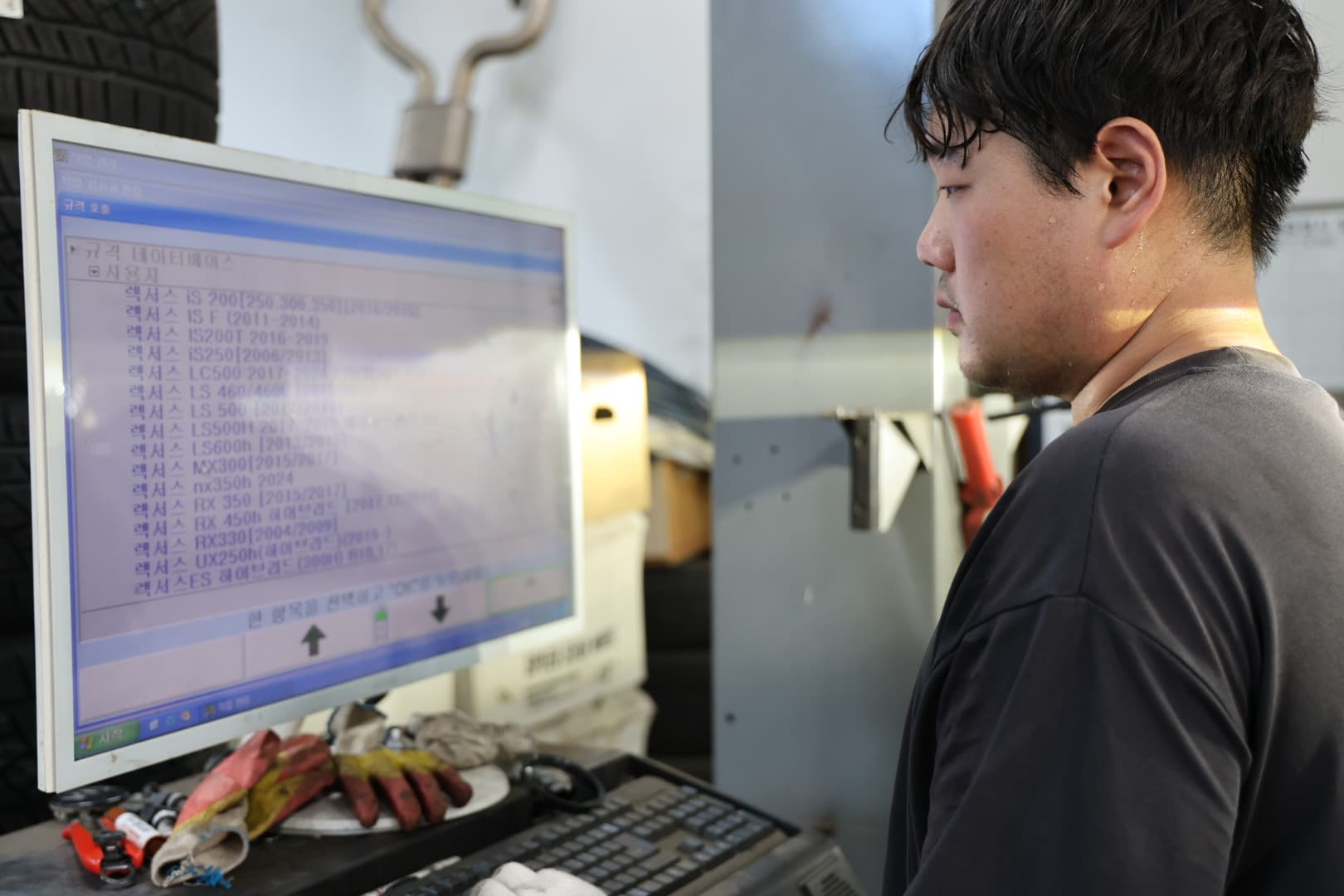 장비 화면에서 차량 규격을 확인하는 작업자